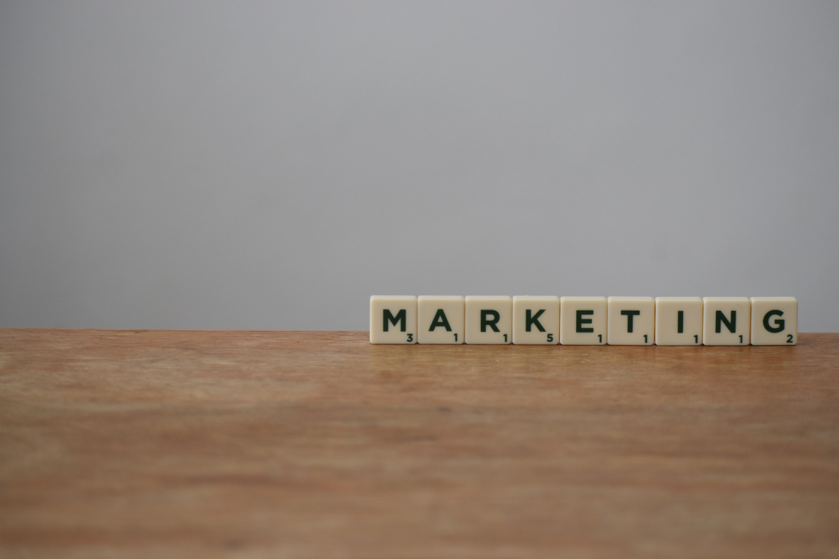 White and Black Marketing Word on Brown Wooden Table